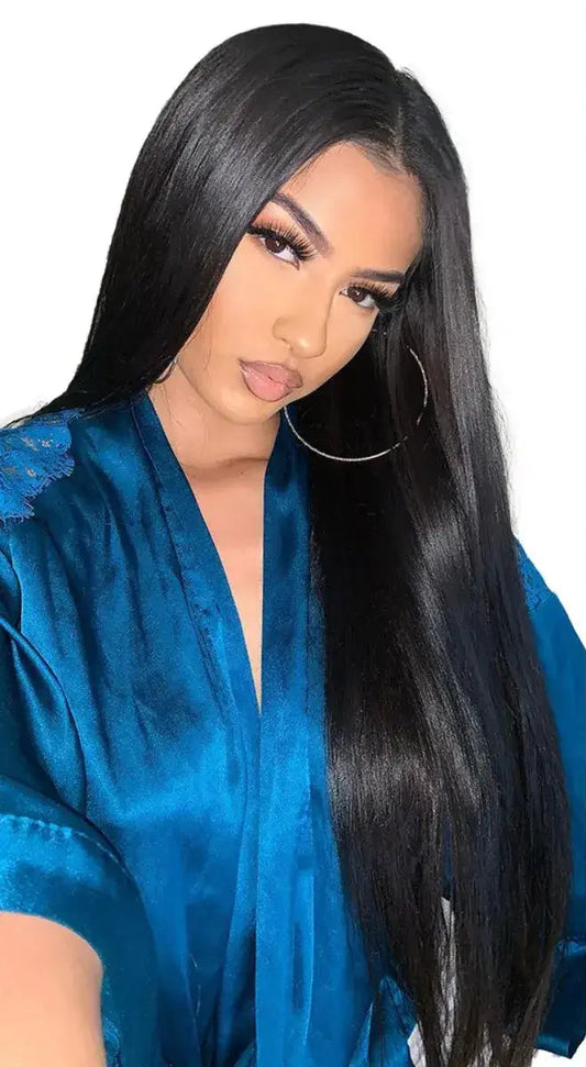 Woman with long black hair next to a wig on a mannequin head.